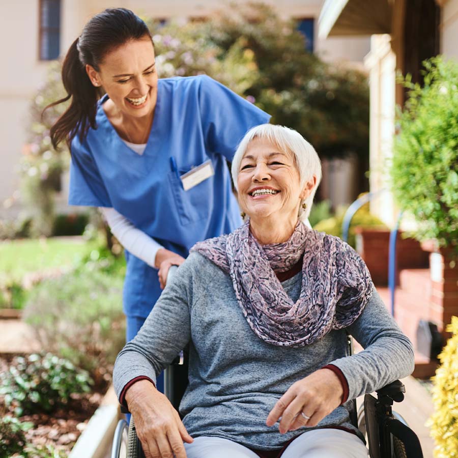 nurse pushing a woman in a wheel chair